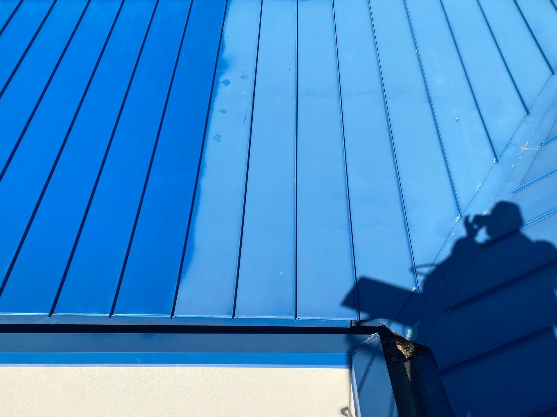 Our commercial painting contractors in Wichita, KS painting a faded metal roof. 