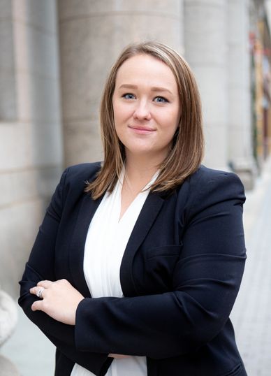 Confident woman in business attire posing outdoors.