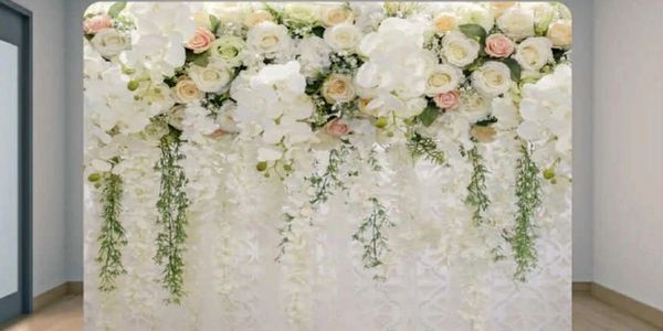 Elegant floral backdrop with cascading white and pastel flowers in a modern room.