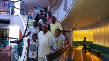 A group of people posing on a modern staircase inside a building.