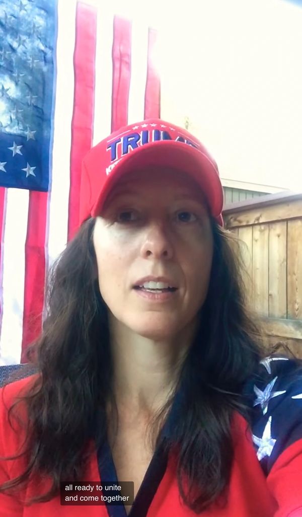 Woman wearing a red Trump hat and patriotic clothing with an American flag backdrop.