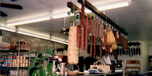 Hanging sausages and deli meats in a store.