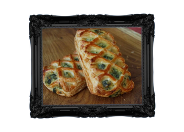 Golden puff pastries with spinach and cheese filling on a wooden surface.