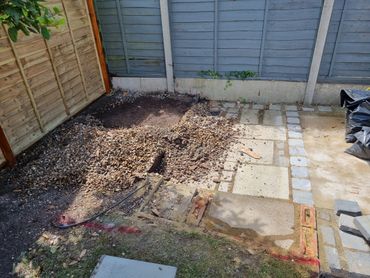 A partially paved garden area with gravel and paving stones under construction.