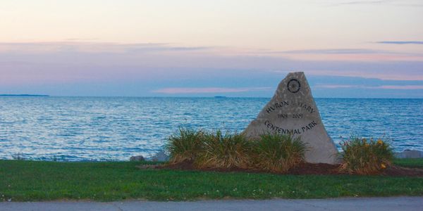 Large lakeside rock with Huron Centennial Park written on it