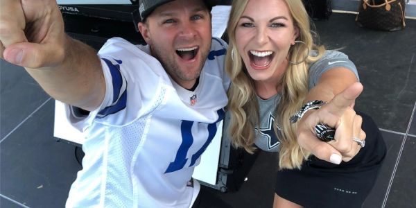 Excited couple pointing at the camera wearing Dallas Cowboys gear.