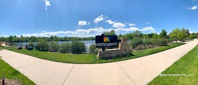 Panoramic view of Northglenn city park with lake and clear blue sky.