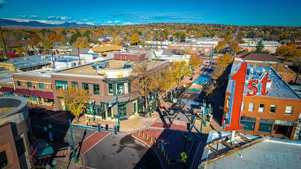 A vibrant small-town street in autumn with colorful trees and a large "1st" sign.