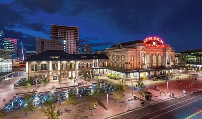 Union Station Denver illuminated at night with cityscape background.