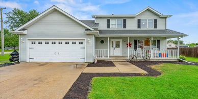 A two-story suburban house with a garage and a porch.