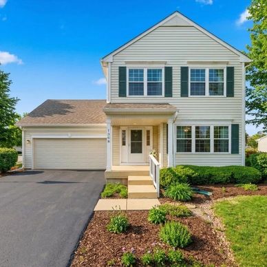 Two-story suburban house with attached garage and landscaped front yard.