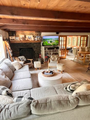 Cozy living room with gray sectional sofa and wooden ceiling.