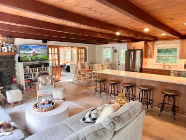Cozy open living room and kitchen with wooden beams.