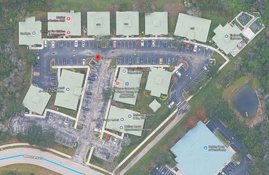 Aerial view of office complex with parking lot.