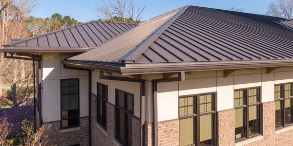 Modern house with metal roof and large windows.