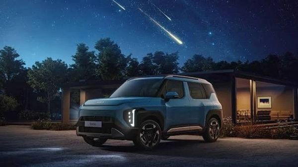 Modern electric SUV parked at night under meteor shower.