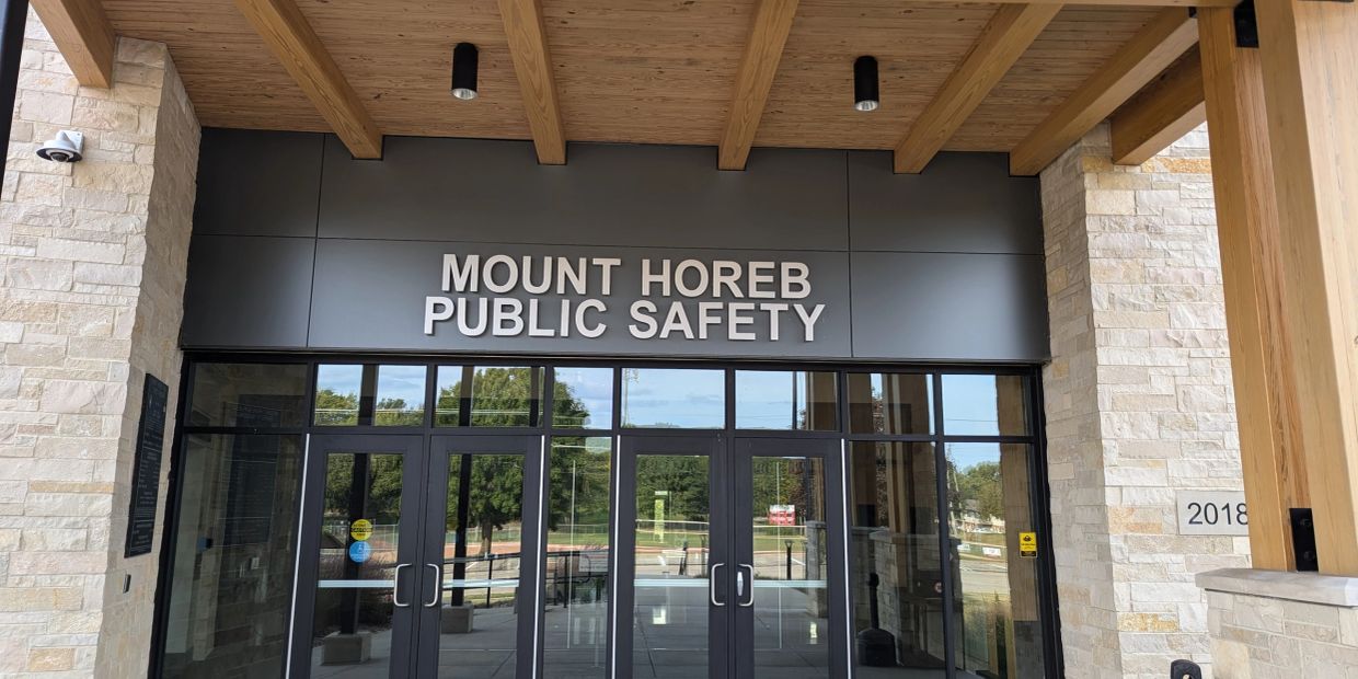 Entrance of Mount Horeb Public Safety building with glass doors and wooden ceiling beams.
