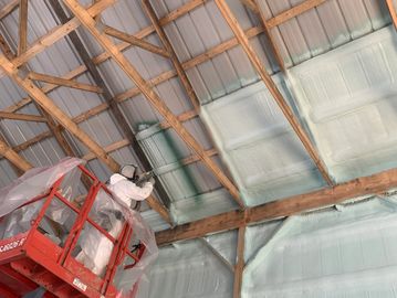 Barn roof getting spray foam insulation installed.