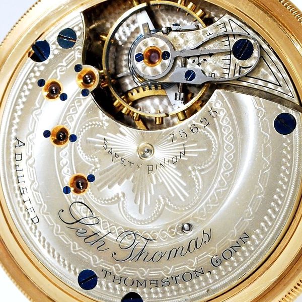 Close-up of intricate Seth Thomas pocket watch mechanism with engraved details.
