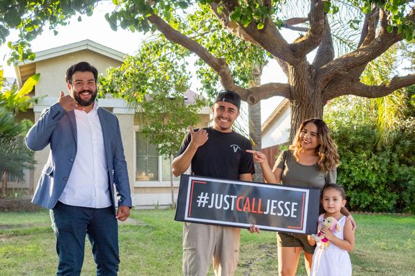 Group holding #JUSTCALLJESSE sign outdoors.