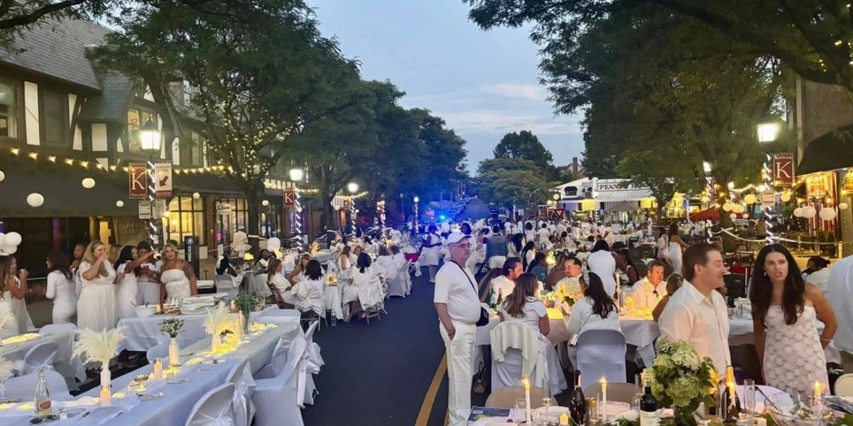 Outdoor street party with people dressed all in white.