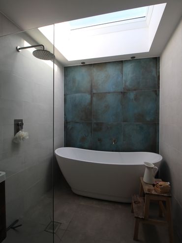 Modern bathroom with a freestanding tub and skylight.