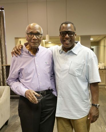 Two men smiling and posing indoors.