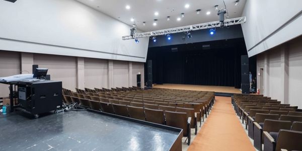 Empty auditorium with stage and rows of seats.