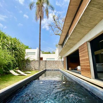 Casa con diseño moderno en alberca y jardín