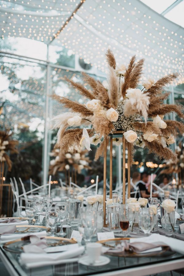Elegant centerpiece with dried flowers and white roses at a wedding.