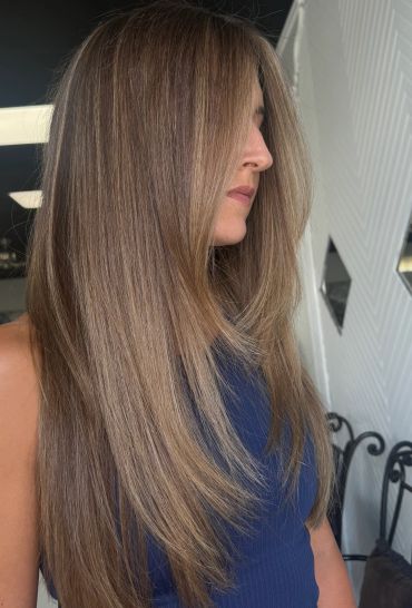 Woman with long, smooth, light brown hair wearing a navy top.