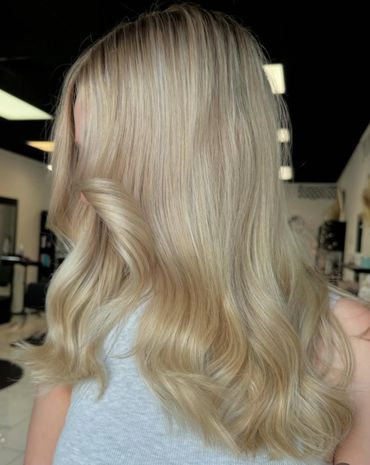 Shiny, wavy blonde hair styled elegantly in a salon.