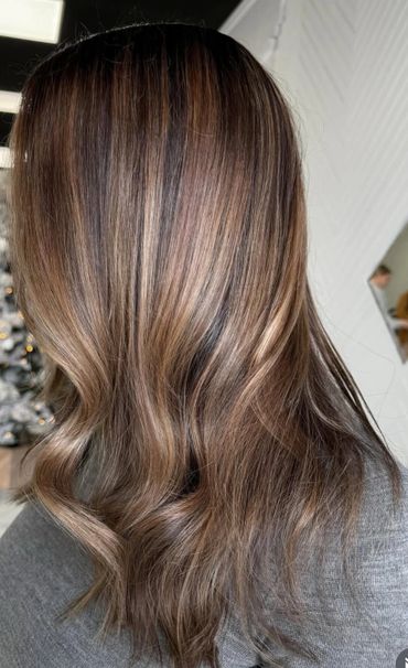 Smooth, wavy brown hair with subtle highlights.