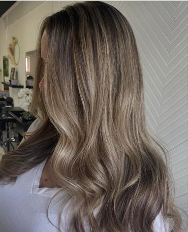 Long, wavy hair with a soft balayage in natural light.