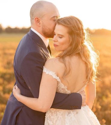 Couple embraces lovingly during golden hour outdoors.