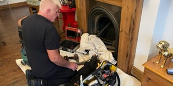 a man cleaning a chimney from inside the house