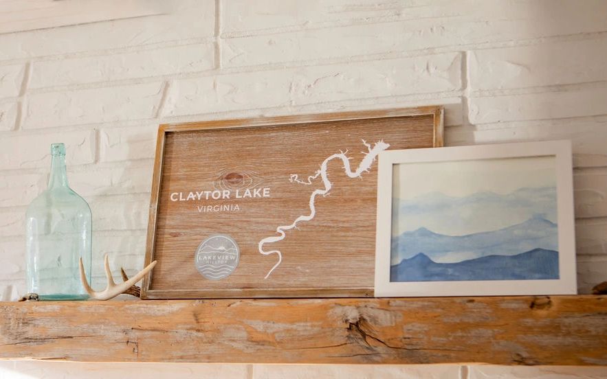 Fireplace mantle with Claytor Lake map and Blue Ridge Mountains artwork