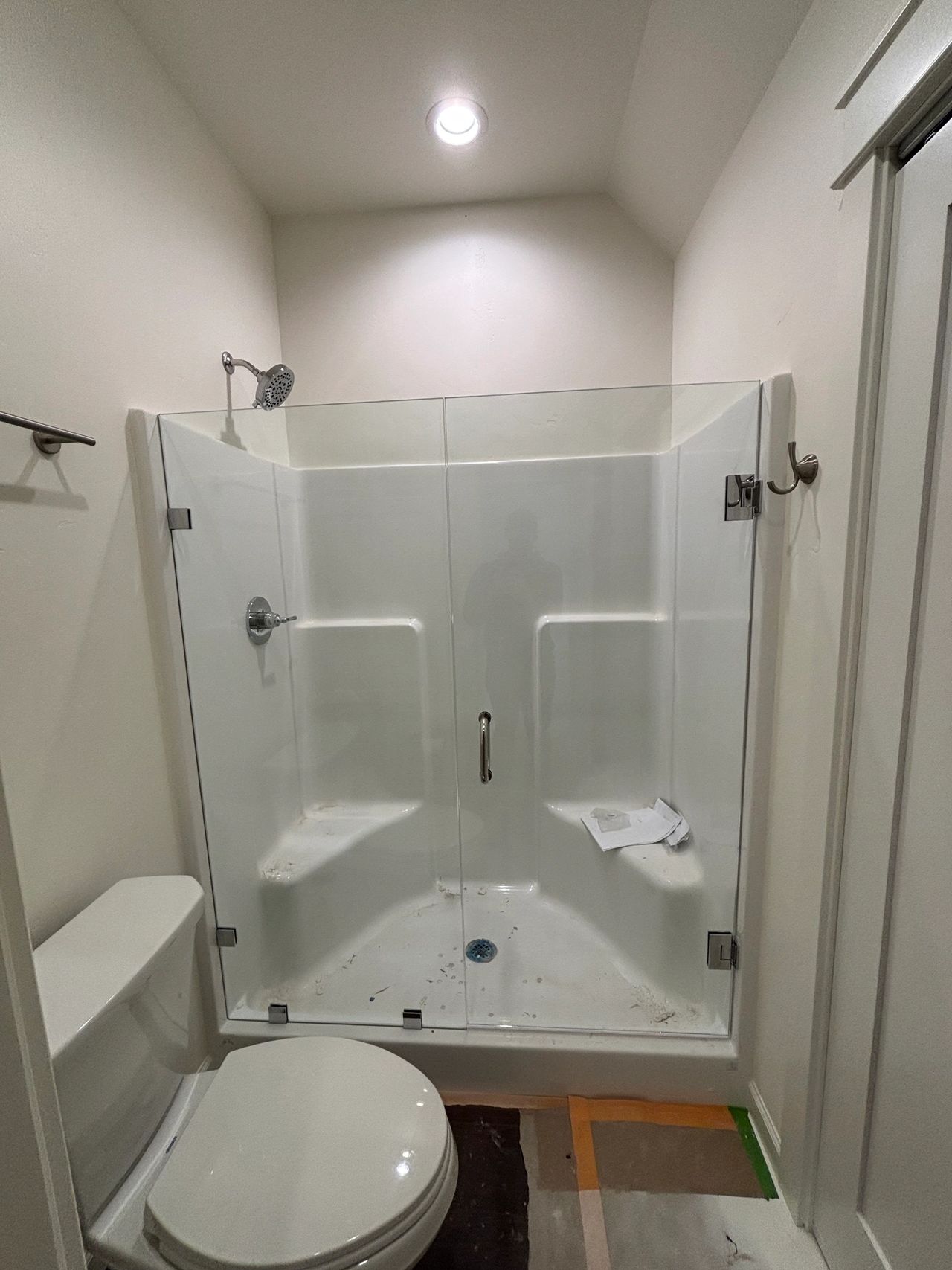 A shower insert with custom fixed panel shower glass and custom shower glass door with chrome shower hardware