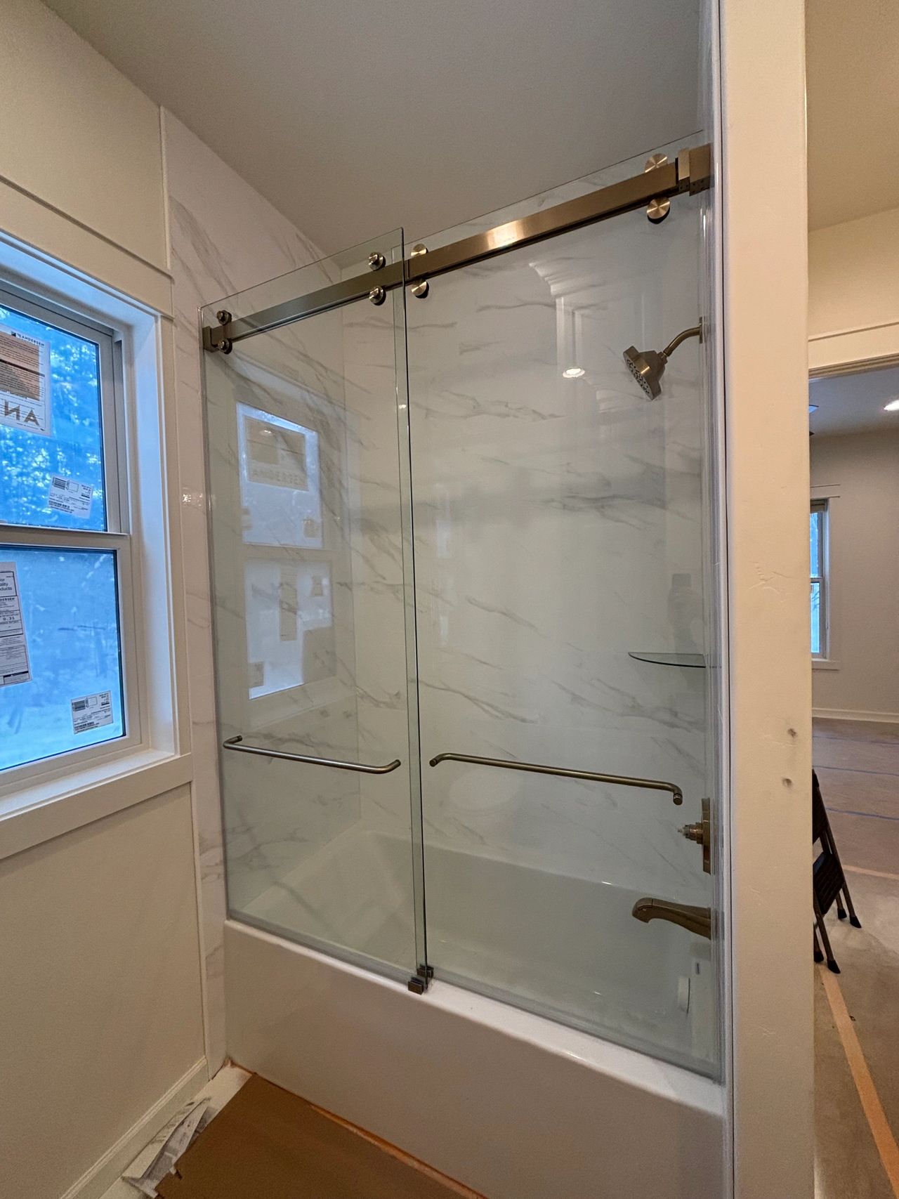 Custom bypass tub shower with bronze hardware installed by Brett, the Precision Glass lead custom shower installer