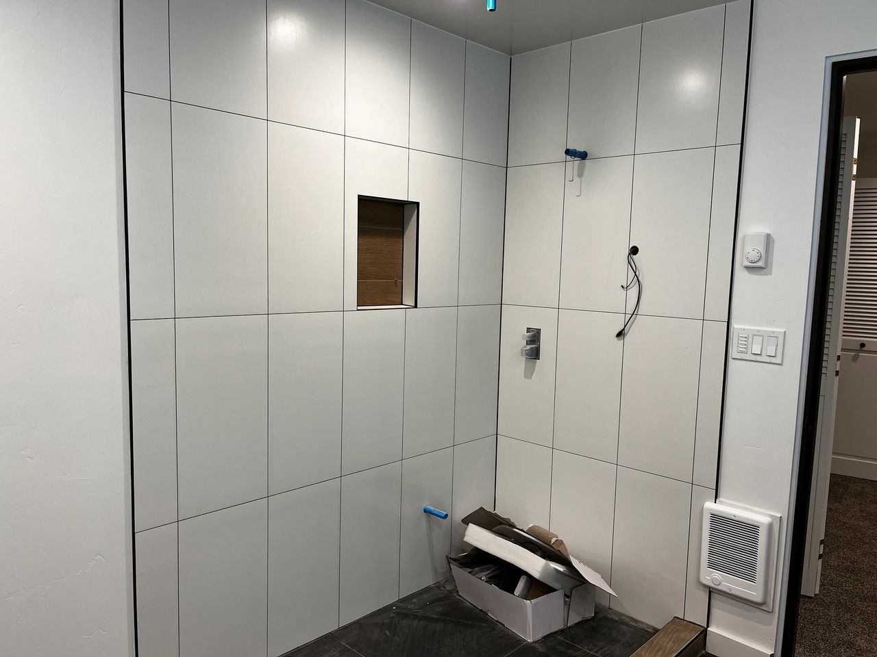 The tile shower prepared for the custom glass enclosure to be installed.