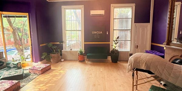 Bright, cozy room with purple walls, large windows, and comfortable seating.