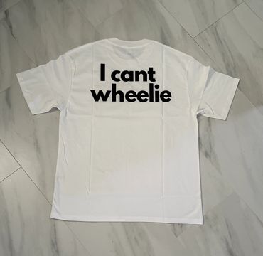 White t-shirt with bold black text saying 'I cant wheelie' on the back.