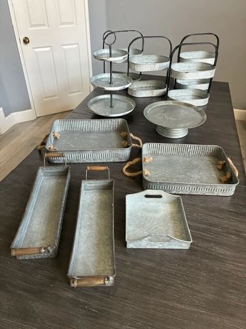 Metal serving trays and tiered stands on a table.