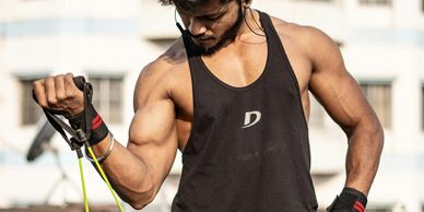 man in workout tank doing bicep curl with resistance band