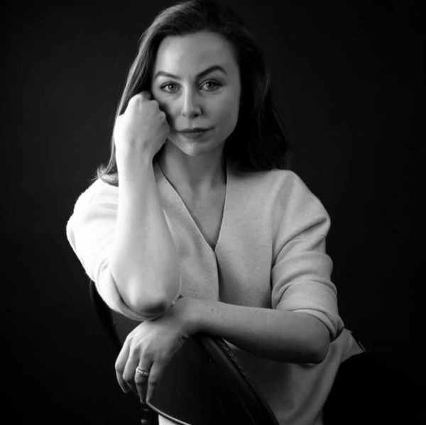 Black and white portrait of a woman posing confidently.