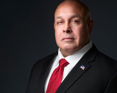 Portrait of a William D. Colon (Willie Colon Jr) in a suit with an American flag pin.