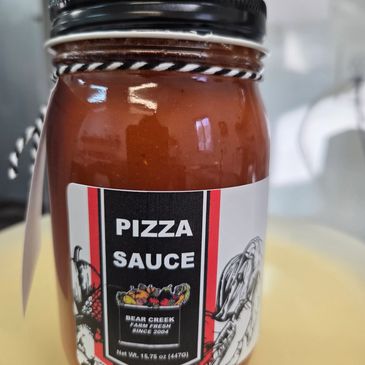 Jar of Bear Creek Farm fresh pizza sauce with decorative label and black lid.