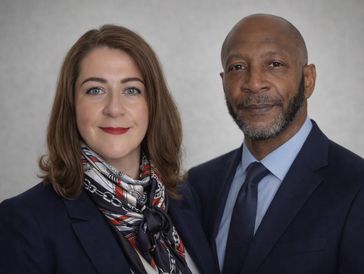 Professional man and woman posing together.