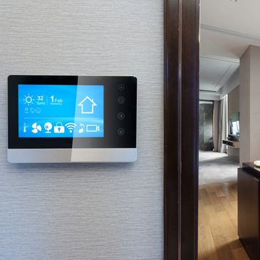 Tablet on wall for home automation beside a door, showcasing smart home services