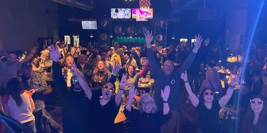 Excited crowd enjoying a lively night at a club or bar.